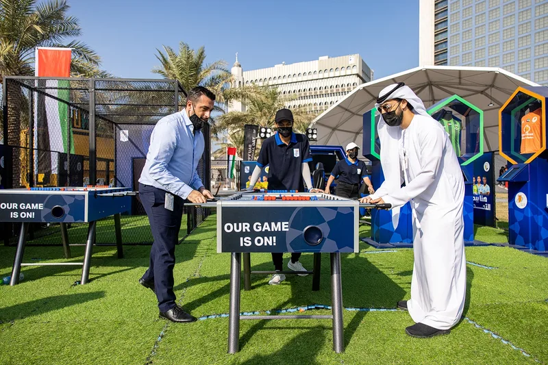 Emirati colleagues posing beside the supersized #50more installation at ADNOC headquarters