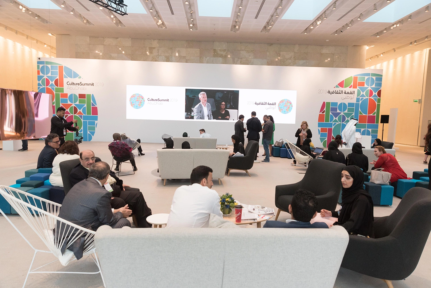 Evolution Furniture networking lounge with modular seating and a branded Culture Summit media wall