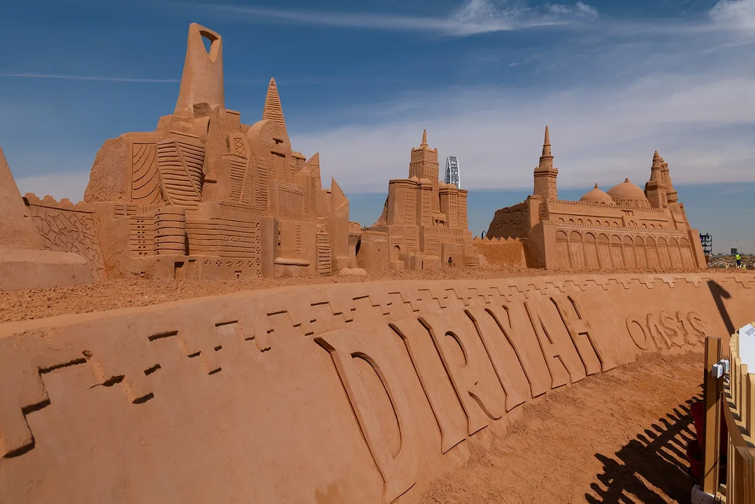 Monumental sand sculpture installation displaying Kingdom Centre and Saudi architectural landmarks at Diriyah Oasis