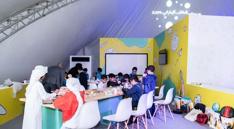 Families and children participating in creative educational art workshops on custom tables