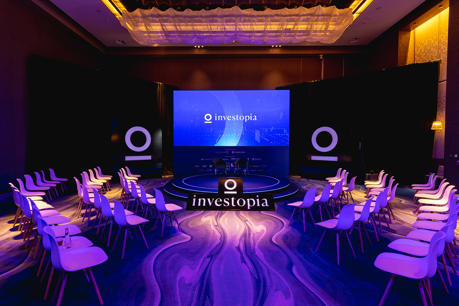 Evolution Events Investopia conference stage with circular platform, LED screen and curved delegate seating