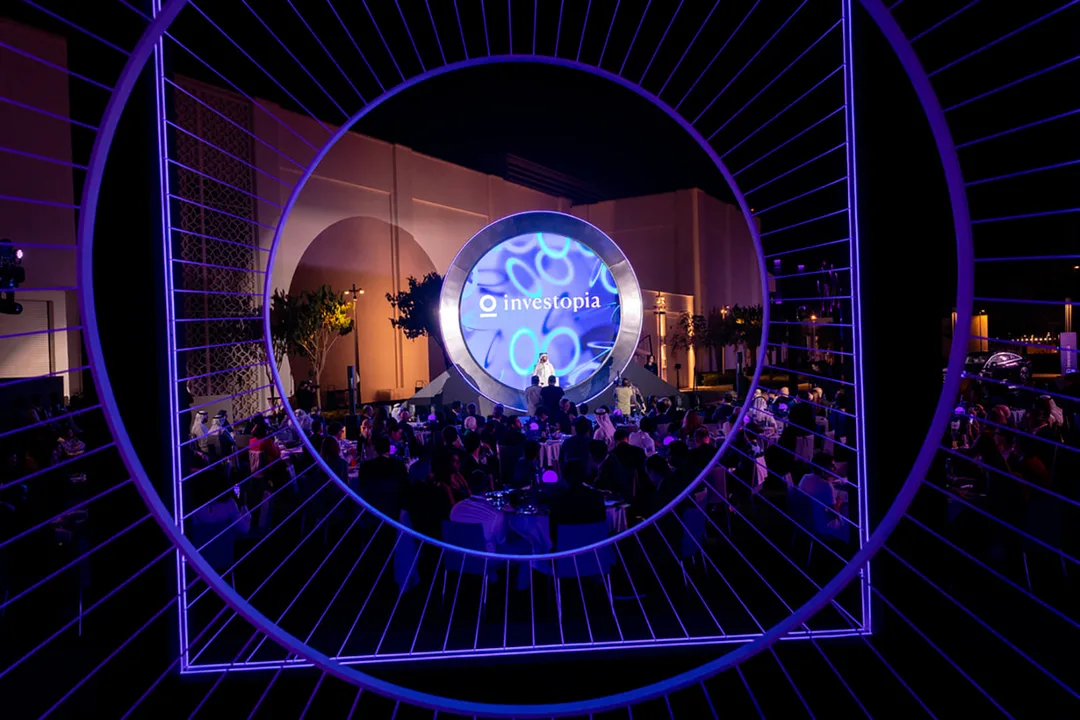 Evolution Events outdoor Investopia gala with circular LED stage framed by an illuminated installation