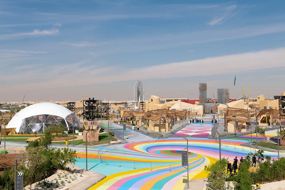 Aerial view of colorful spiral ground graphics, geodesic domes, and festival site infrastructure engineered by Evolution