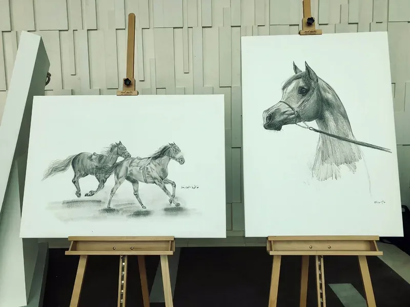 Two detailed graphite drawings of Arabian horses displayed on wooden easels at the For the Love of Horses exhibition.