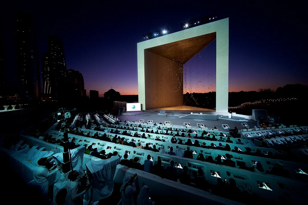 Founder's Memorial launch majlis with mashrabiya-inspired panels, large Sheikh Zayed photographs and custom white furniture.
