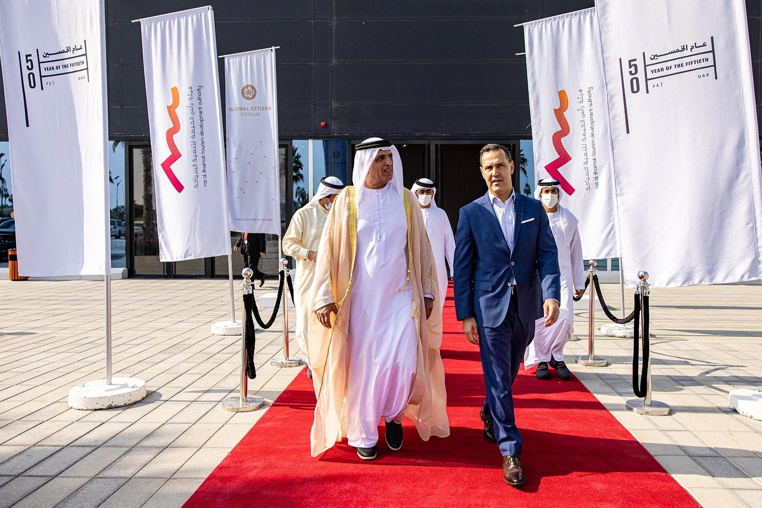 Global Citizen Forum delegates arriving on a red carpet between branded Year of the Fiftieth banners