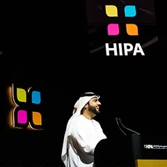 Keynote speaker addressing audience from custom acrylic lectern during Dubai ceremony