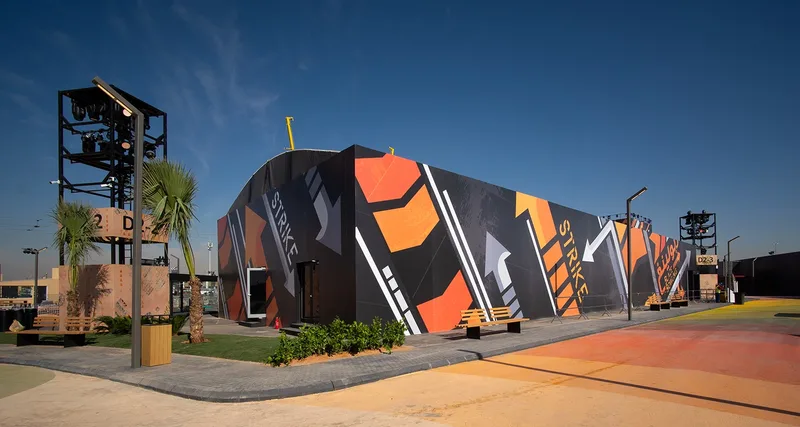 Strike bowling alley temporary venue featuring bold graphic facade and outdoor lighting towers in Riyadh