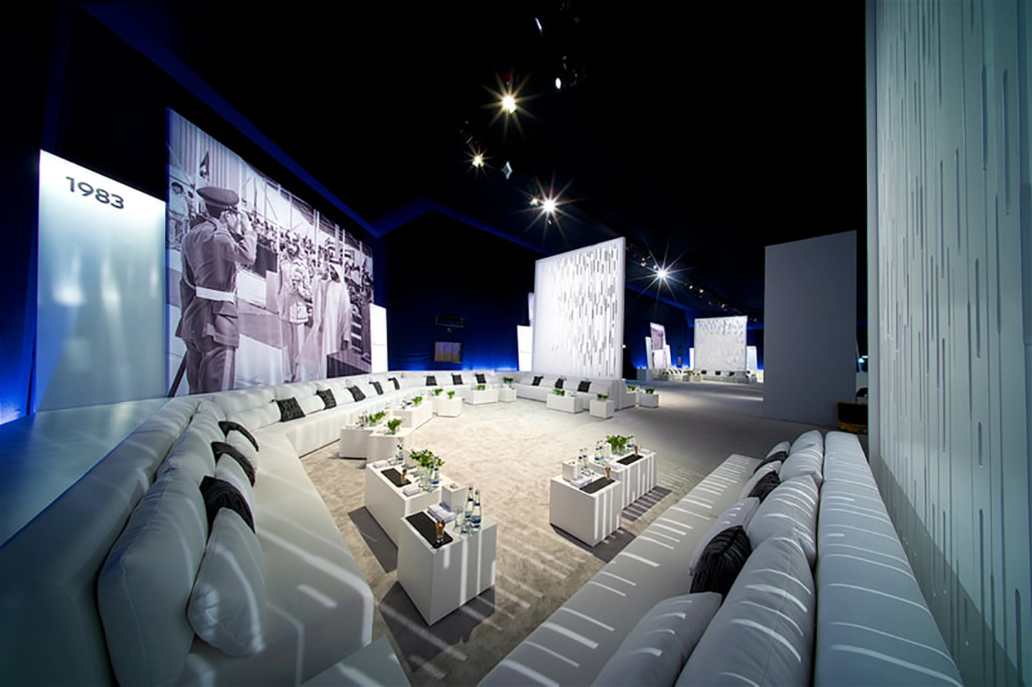 Dignitaries gathered around illuminated memorial art piece during official national ceremony